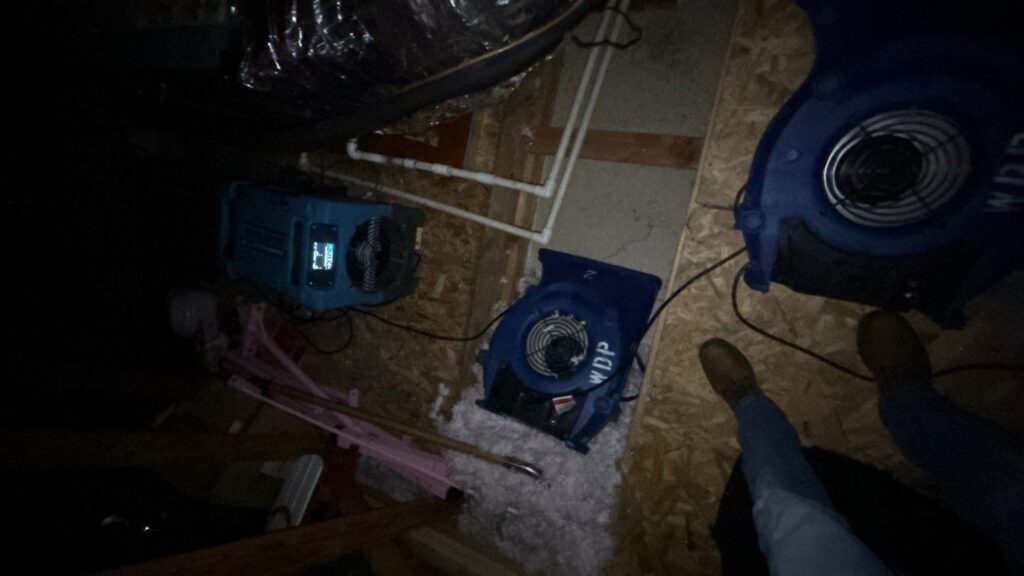 Water damage drying equipment running in a crawlspace to remove trapped moisture