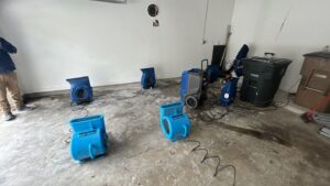 Water damage drying setup in Clarksville, TN, air movers and a dehumidifier used to dry hidden moisture under kitchen cabinets