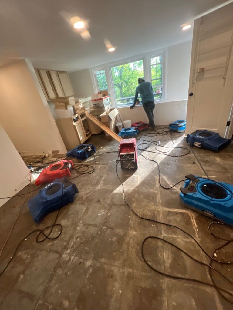 Large room water damage drying equipment with multiple air movers and dehumidifier setup