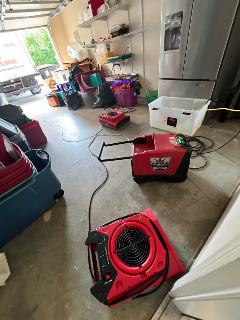 Garage water damage drying equipment with air mover and dehumidifier setup